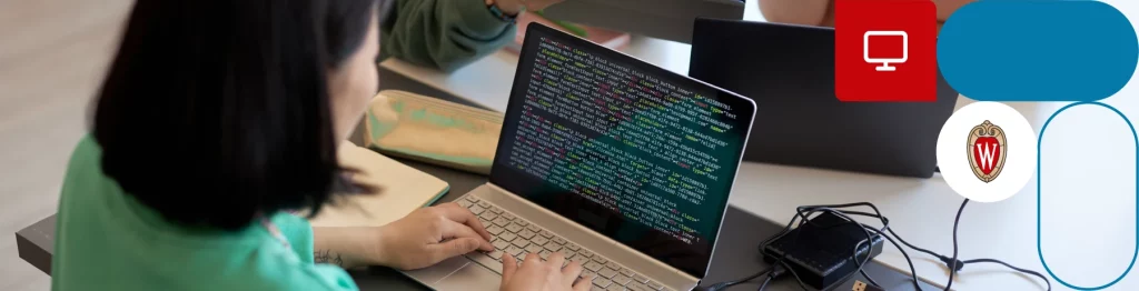 A person in a green shirt typing on a laptop with code on the screen, logos of a play button and shield visible